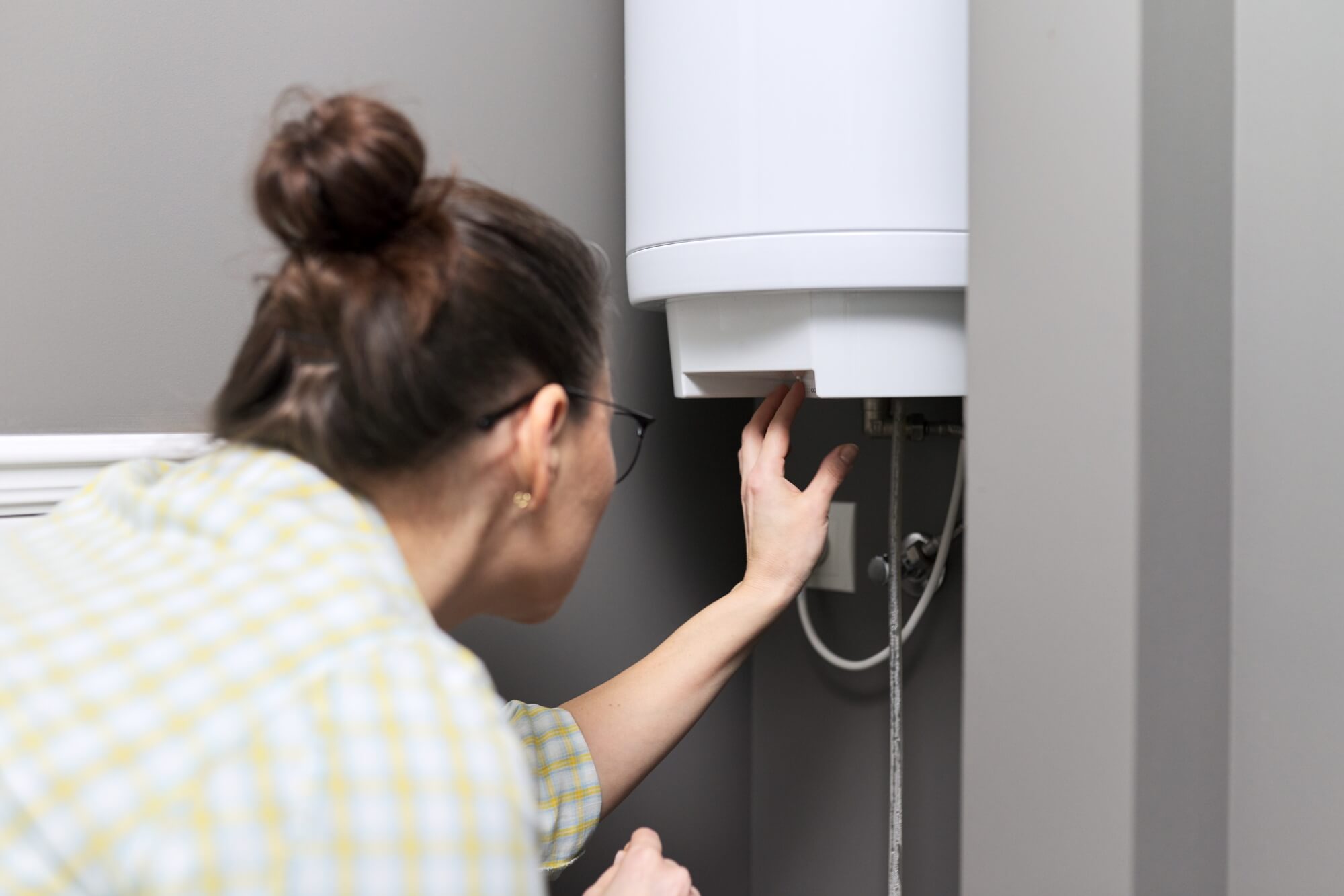 woman-inspecting-water-heater-in-seattle