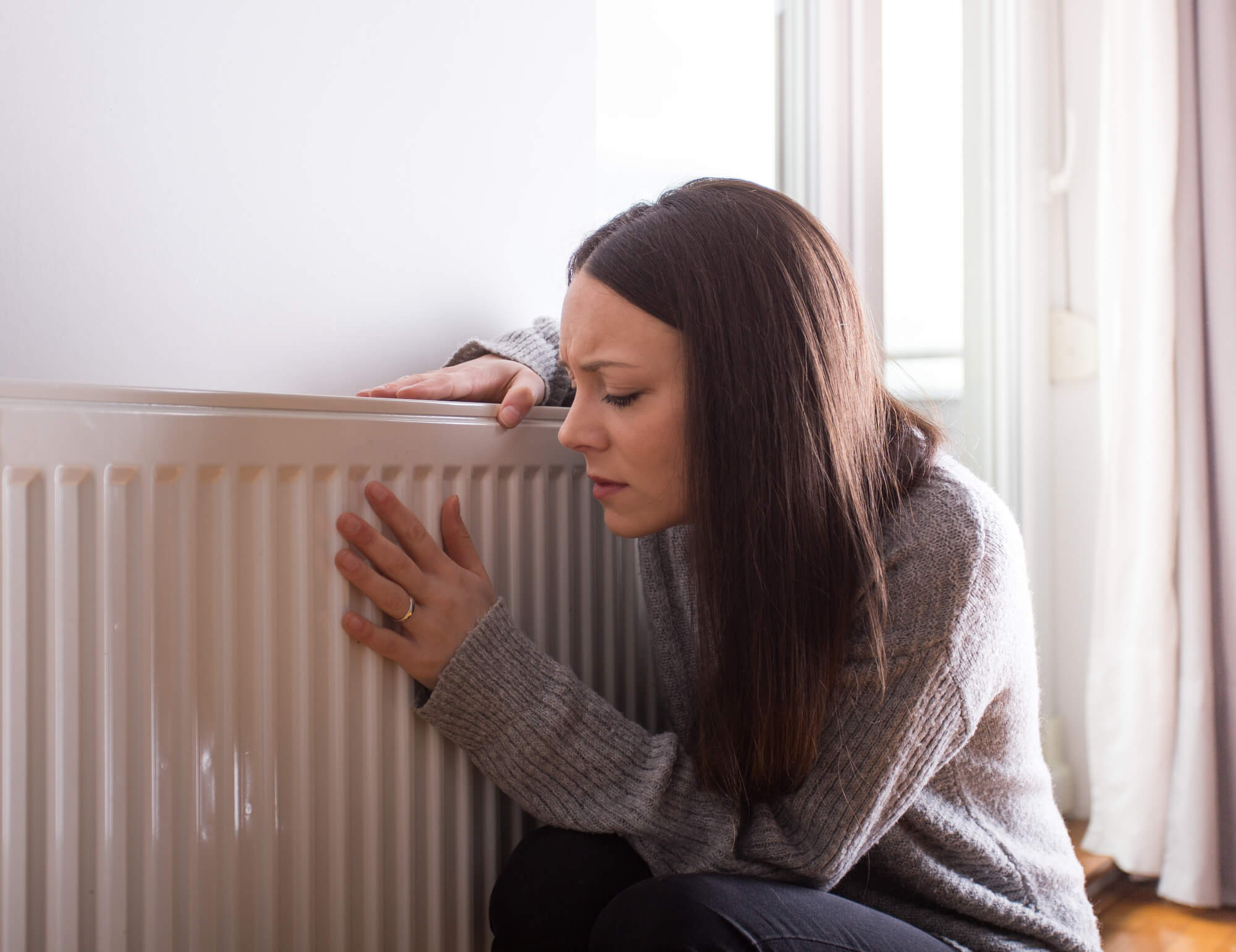 woman next to heating system needs Heating Repair in Seattle