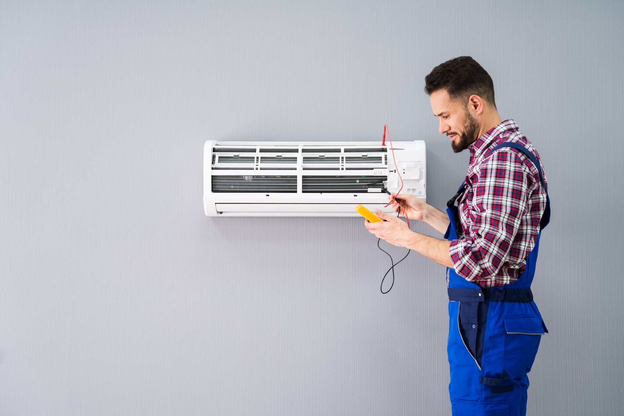 worker checking AC as part of HVAC Services in Seattle