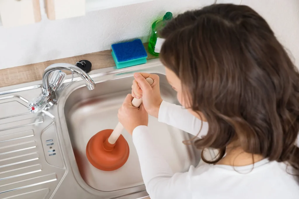 woman attempting to Fix clogged drain Seattle